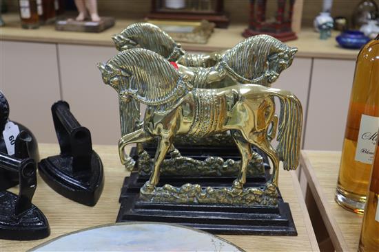 A set of three Victorian brass and iron horse door stops, an iron kettle and three irons